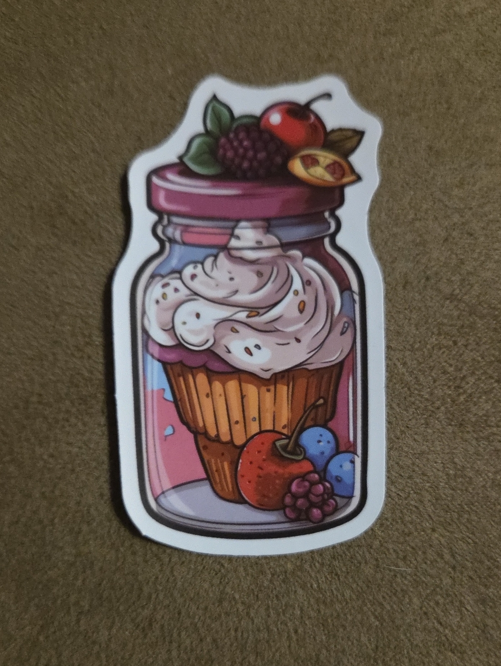 Sticker - Golden Cupcake with White Frosting surrounded by Berries in Jar